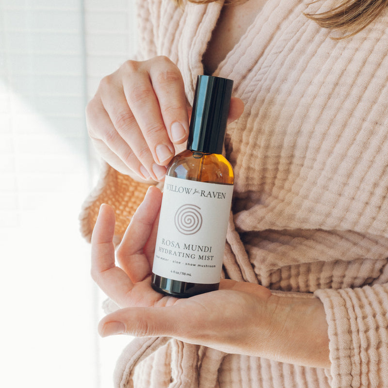 Person holding a bottle of 'Hollow & Raven' product against a neutral background